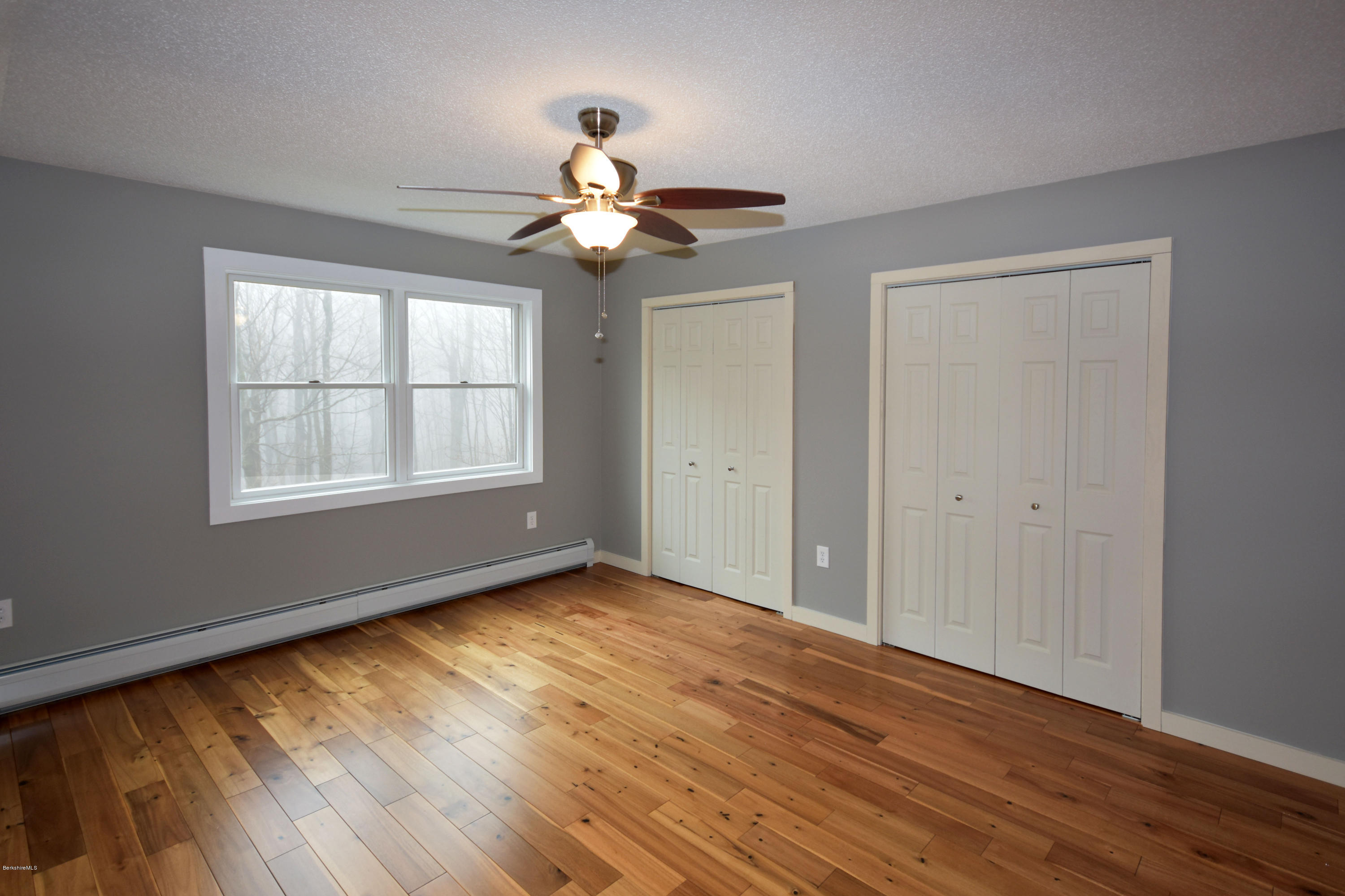 1246 Jacobs Ladder Road Becket, MA 01223 - Photo 33 of 54 a view of an empty room with wooden floor and a window