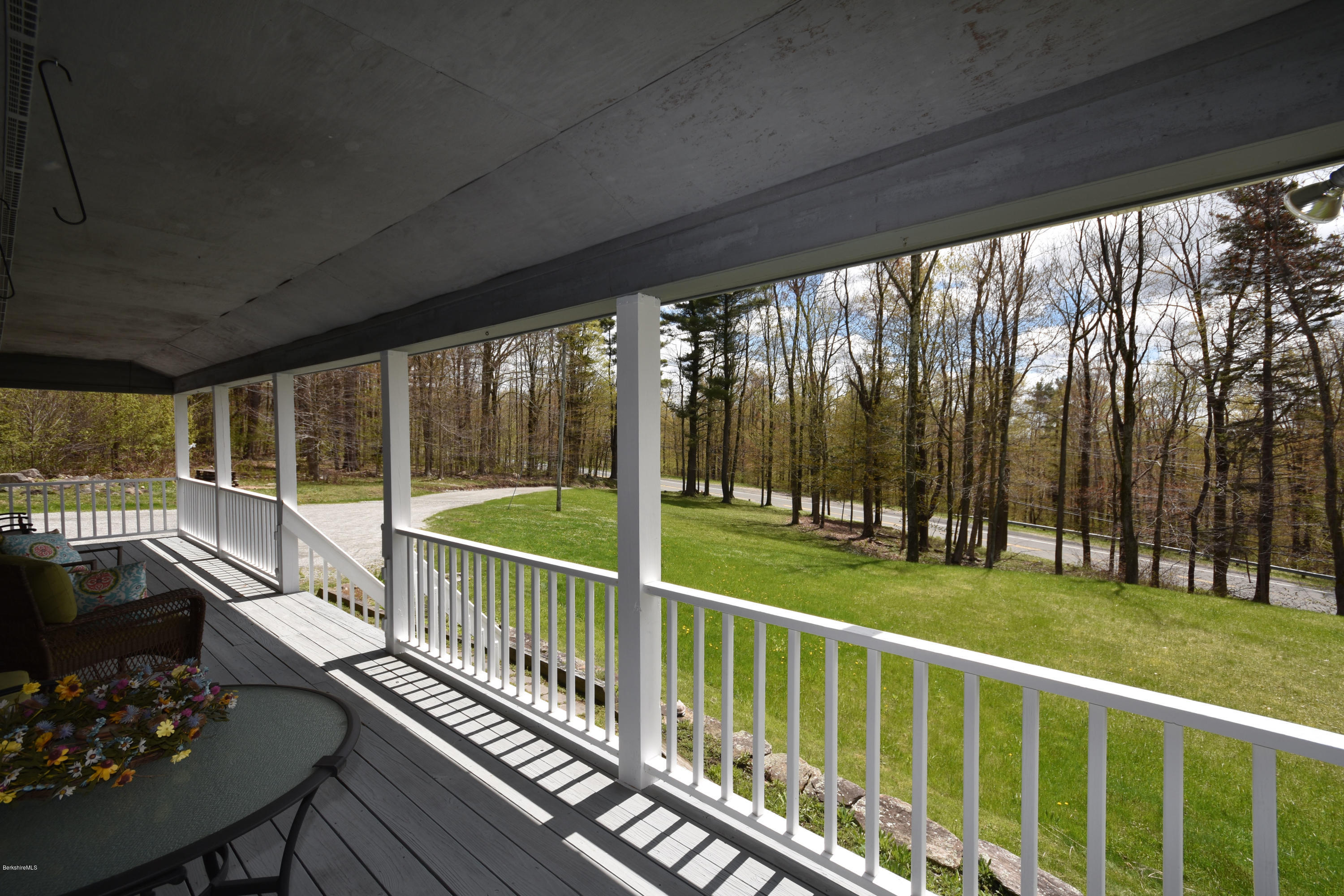 1246 Jacobs Ladder Road Becket, MA 01223 - Photo 5 of 54 a view of a balcony with chairs and floor to ceiling window with wooden fence