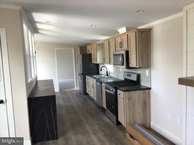 a kitchen with stainless steel appliances granite countertop a stove a sink and a refrigerator