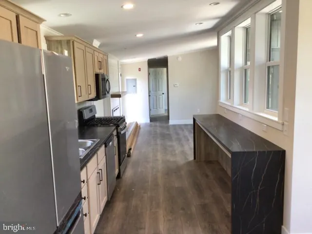 a kitchen with stainless steel appliances granite countertop a refrigerator and a sink