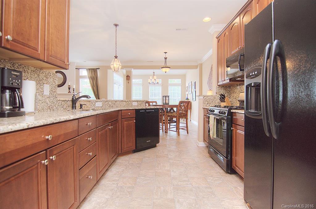 163 Snead Road, Unit 163 Fort Mill, SC 29715 - Photo 3 of 24 a kitchen with stainless steel appliances granite countertop a refrigerator a sink a stove and a wooden cabinets