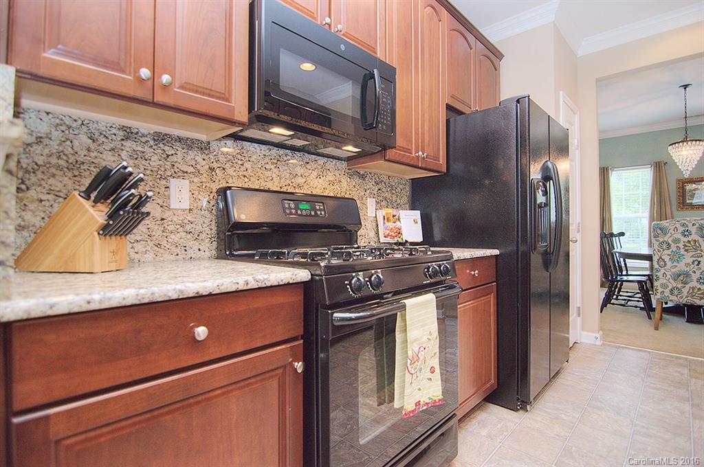 163 Snead Road, Unit 163 Fort Mill, SC 29715 - Photo 5 of 24 a kitchen with granite countertop wooden cabinets and stainless steel appliances