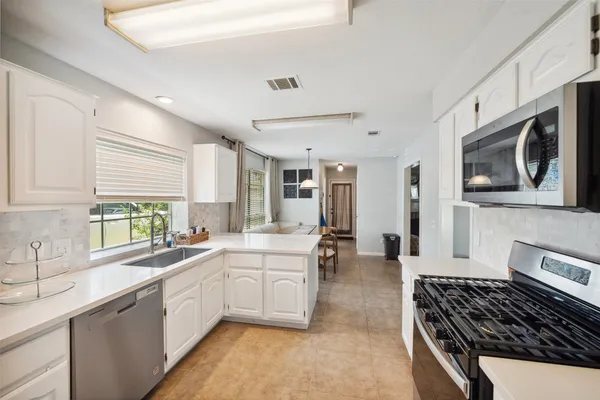 a kitchen with a stove a sink and a microwave
