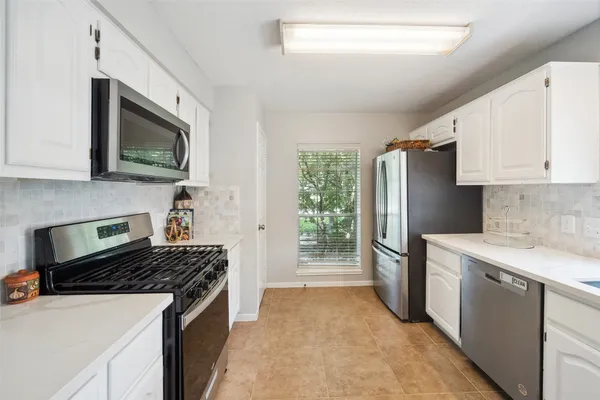 a kitchen with a sink a stove a refrigerator cabinets and a counter top space