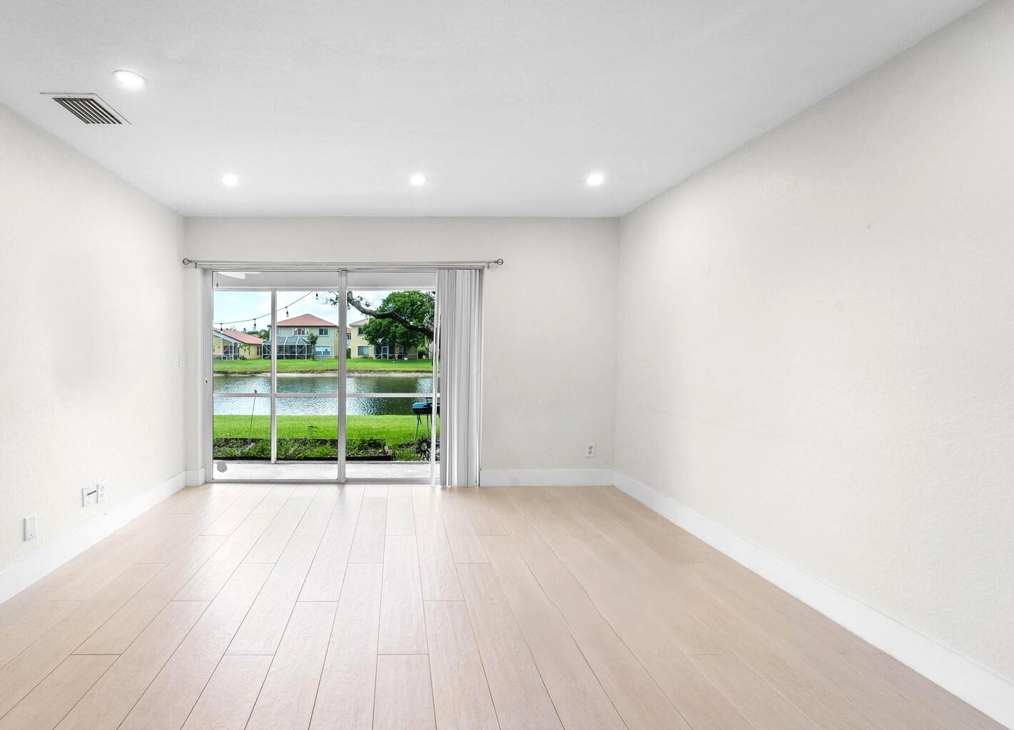 8018 Big Pine Way Riviera Beach, FL 33407 - Photo 2 of 9 a view of an empty room with wooden floor and a window