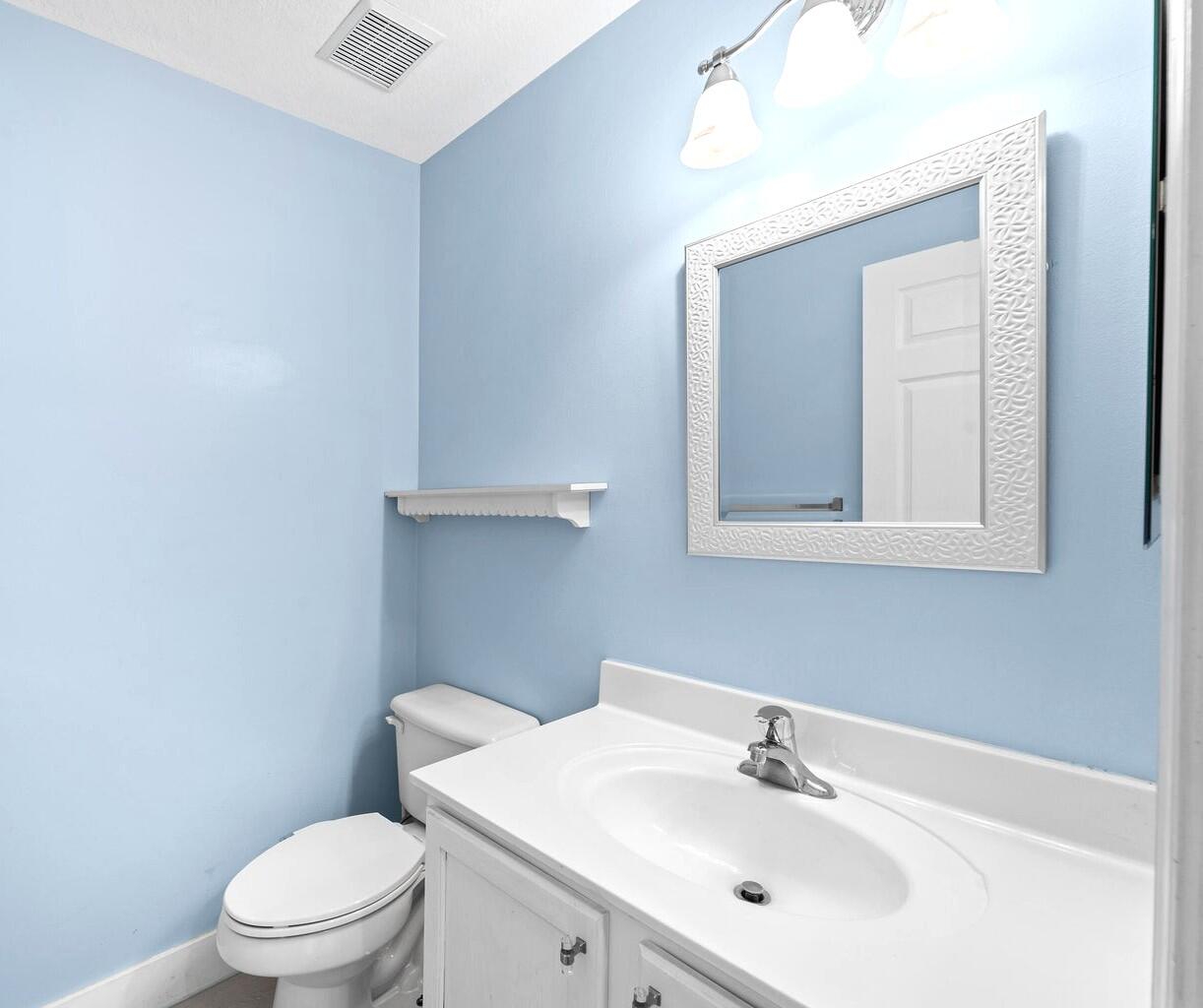 8018 Big Pine Way Riviera Beach, FL 33407 - Photo 5 of 9 a bathroom with a sink a toilet and mirror