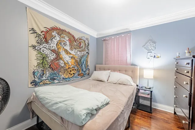 a bedroom with a bed and a painting on the wall