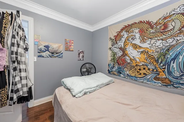 a bedroom with a bed and a painting on the wall