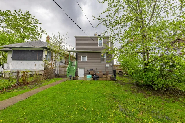 a view of a backyard with table and chairs and a large tree