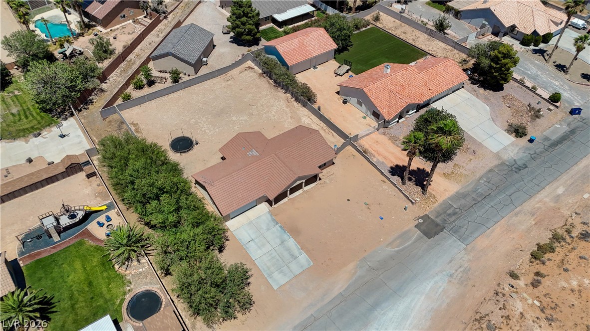 1272 Liston Avenue Logandale, NV 89021 - Photo 53 of 61 An aerial perspective reveals several desert homes, highlighting ample lot sizes and neighboring amenities like swimming pools and play areas.