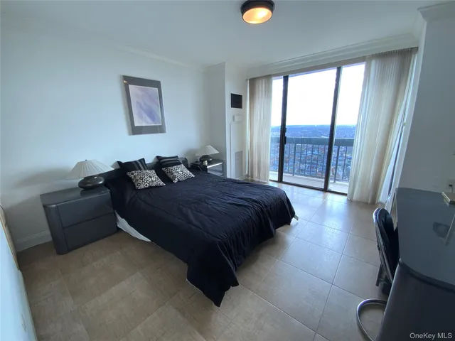 a spacious bedroom with a bed and glass window