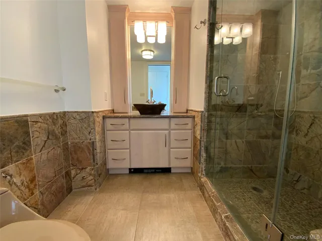 a bathroom with a double vanity sink mirror and shower