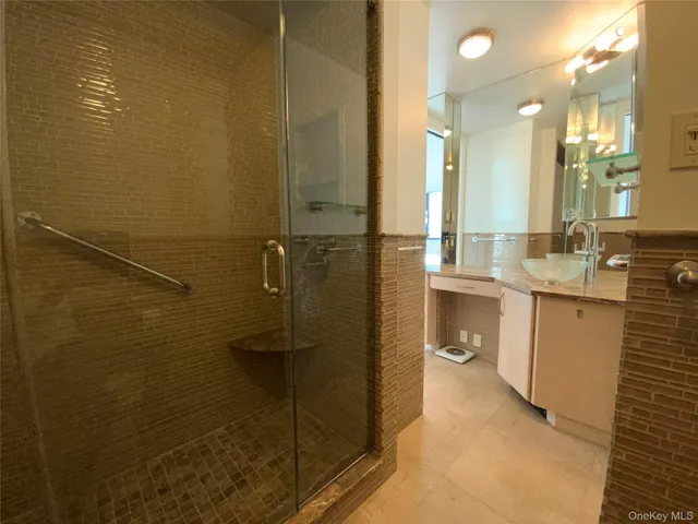 a bathroom with a granite countertop sink mirror and shower