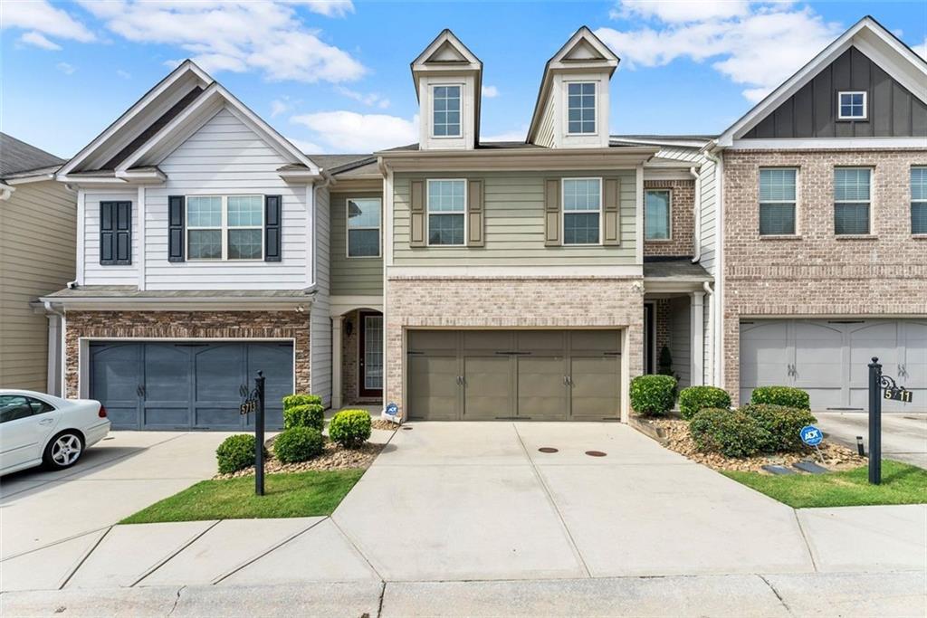 a front view of a house with a garden and garage