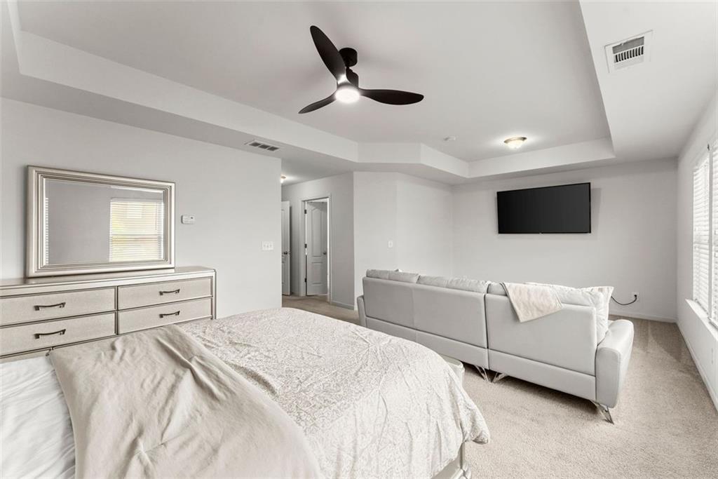 5713 Radford Loop Fairburn, GA 30213 - Photo 16 of 43 a bedroom with a bed and a flat screen tv