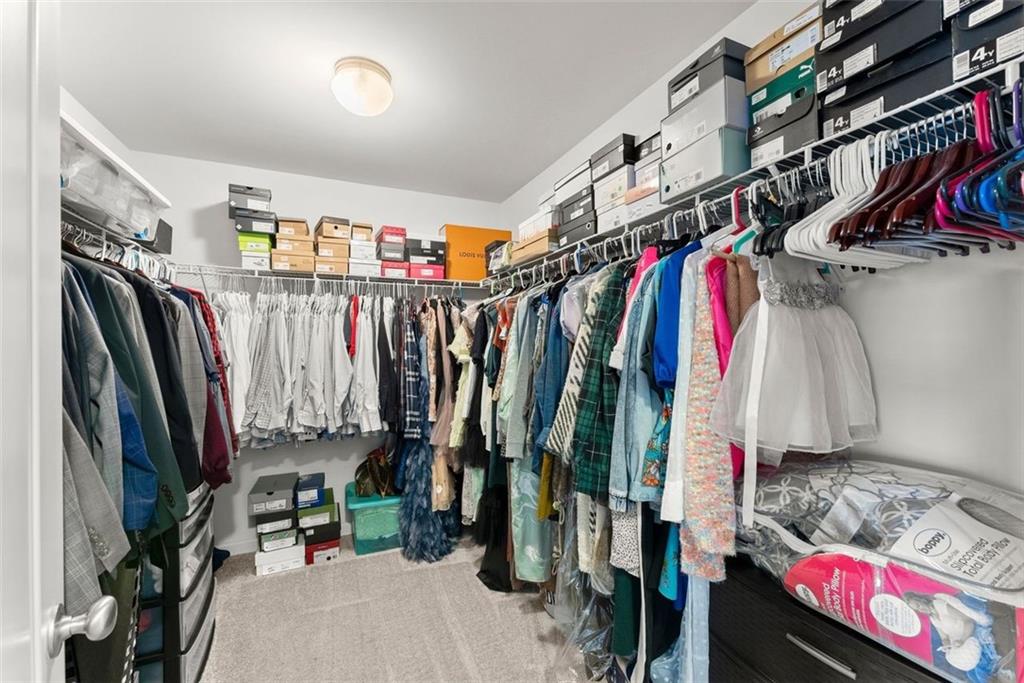5713 Radford Loop Fairburn, GA 30213 - Photo 22 of 43 a view of walk in closet with clothes and shoes