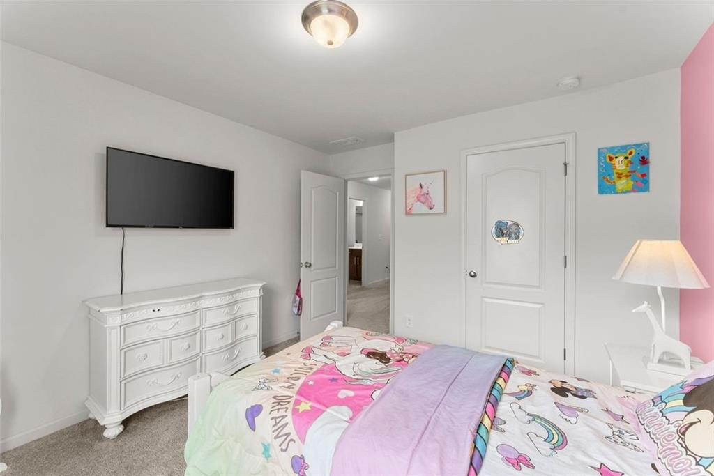 5713 Radford Loop Fairburn, GA 30213 - Photo 30 of 43 a bedroom with a bed and a flat screen tv