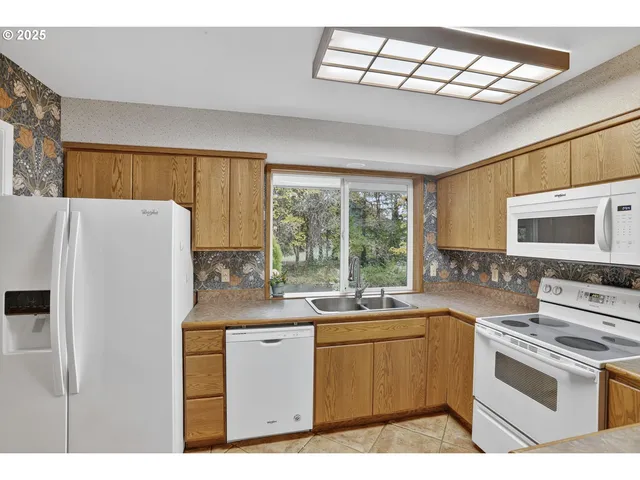 a kitchen with a sink a stove a refrigerator and a window