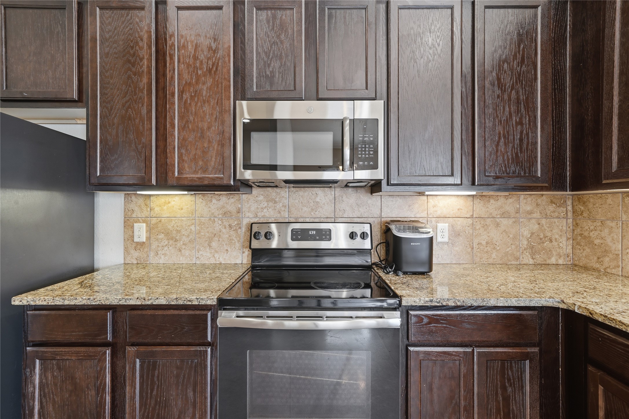 533 Jack Rabbit Lane, Unit A Buda, TX 78610 - Photo 17 of 34 A compact kitchen with sleek appliances and practical stone counters.