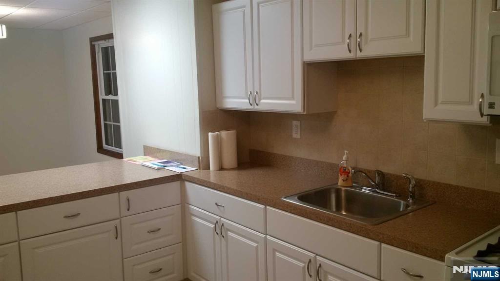 196 Rock Road, Unit 2B Glen Rock, NJ 07452 - Photo 9 of 22 a kitchen with stainless steel appliances granite countertop white cabinets and a sink