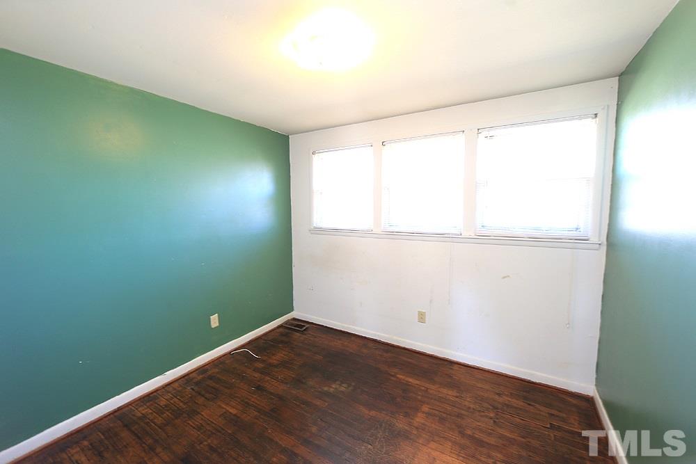 848 Newcombe Road Raleigh, NC 27610 - Photo 11 of 14 an empty room with wooden floor and windows
