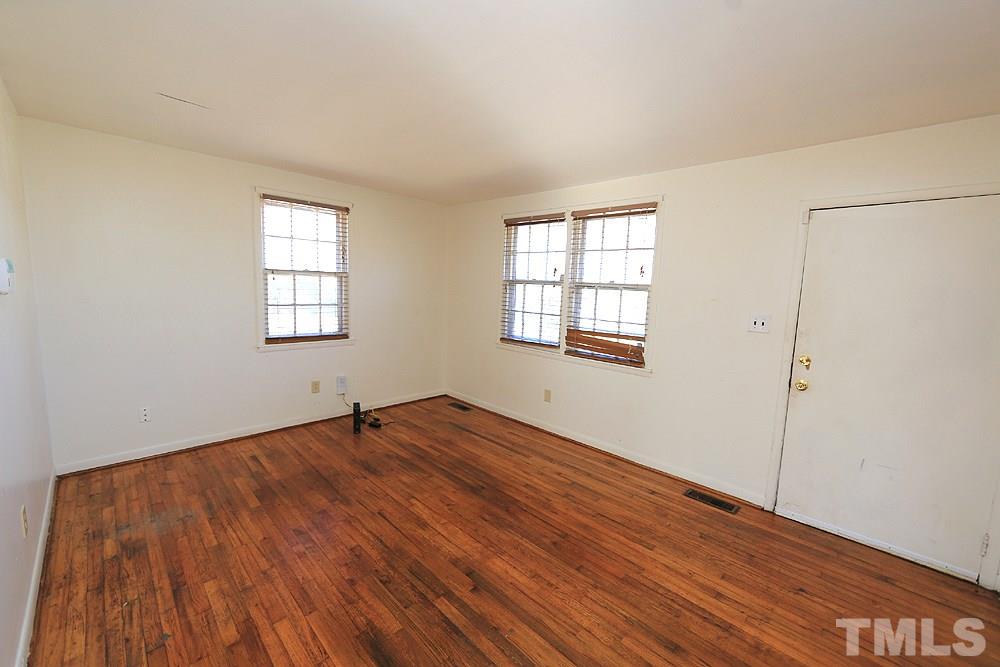 848 Newcombe Road Raleigh, NC 27610 - Photo 3 of 14 an empty room with wooden floor and windows