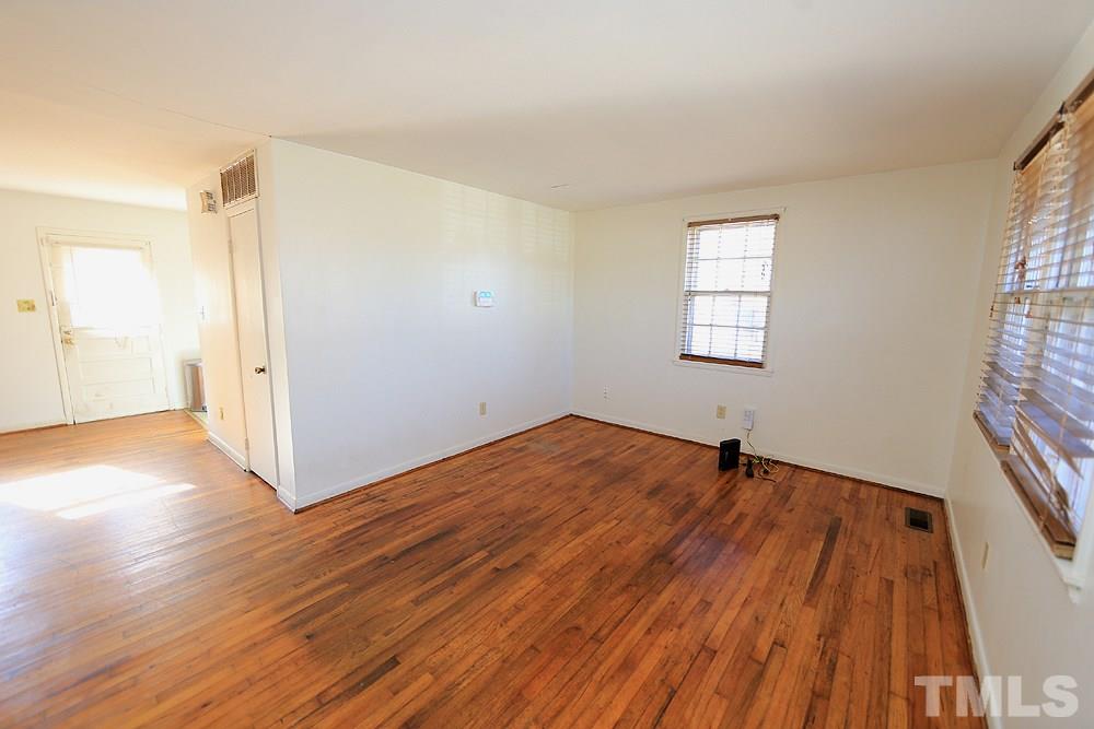 848 Newcombe Road Raleigh, NC 27610 - Photo 4 of 14 an empty room with wooden floor and windows