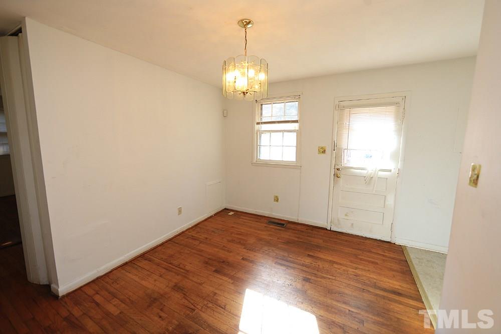 848 Newcombe Road Raleigh, NC 27610 - Photo 7 of 14 an empty room with wooden floor and windows