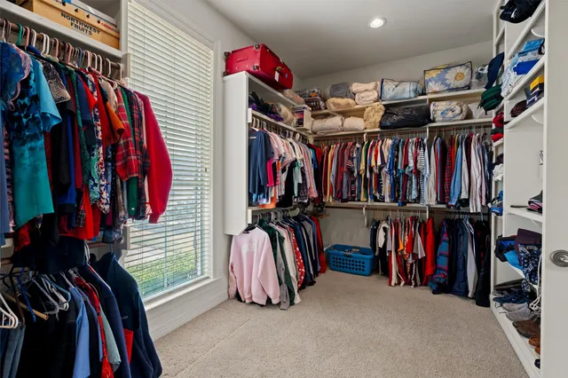 a view of walk in closet with clothes