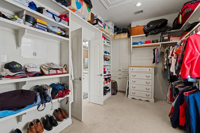 a view of walk in closet with clothes and shoes