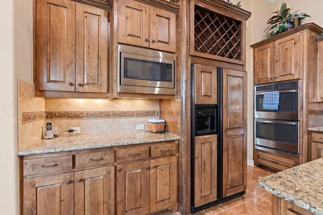 a kitchen with granite countertop stainless steel appliances a stove and refrigerator