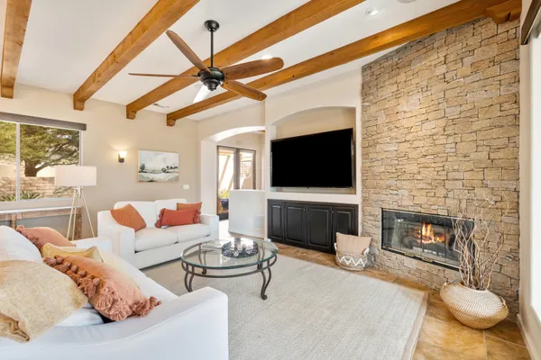 a living room with furniture a flat screen tv and a floor to ceiling window