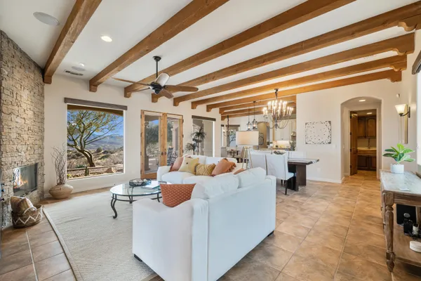 a living room with furniture a flat screen tv and a floor to ceiling window