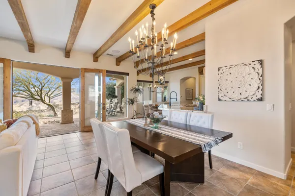 a living room with stainless steel appliances furniture a rug and a chandelier