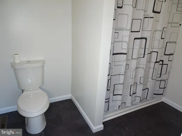 a bathroom with a toilet and a shower curtain