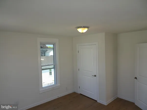an empty room with windows and closet