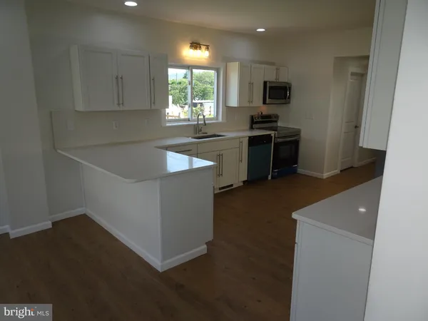 a kitchen with granite countertop a sink and a stove top oven