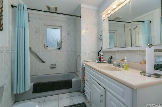 250 North Rutherford Avenue Massapequa, NY 11758 - Photo 9 of 21 a bathroom with a sink a toilet and shower