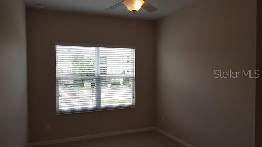 7652 Ripplepointe Way Windermere, FL 34786 - Photo 14 of 21 a view of an empty room with a window and a lamp
