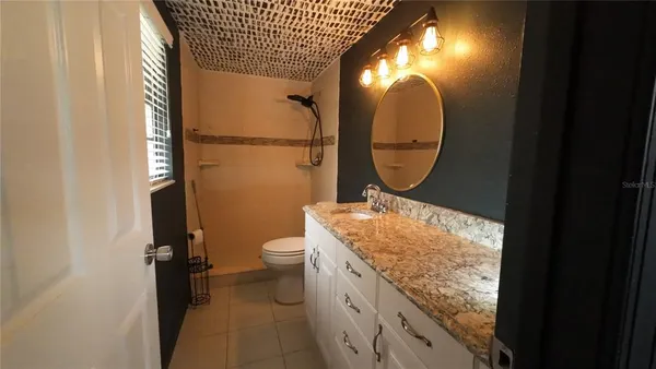 a bathroom with a toilet mirror and vanity