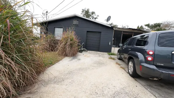 a front view of house with yard and trees in the background