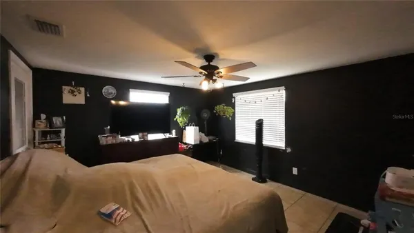 a bedroom with a bed mirror and a chandelier