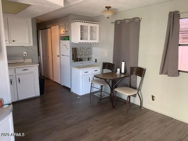 a living room with stainless steel appliances granite countertop furniture wooden floor and a kitchen view