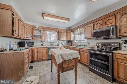 a kitchen with stainless steel appliances granite countertop a stove sink microwave and refrigerator