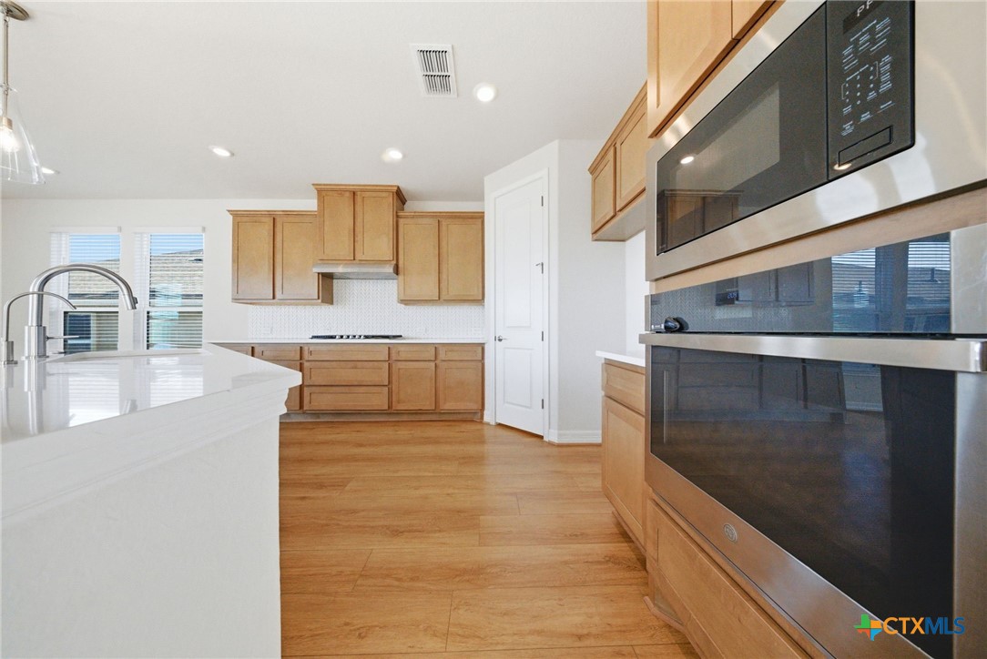 662 Hidden View Street New Braunfels, TX 78130 - Photo 18 of 46 a large kitchen with stainless steel appliances kitchen island granite countertop a large counter top and a stove