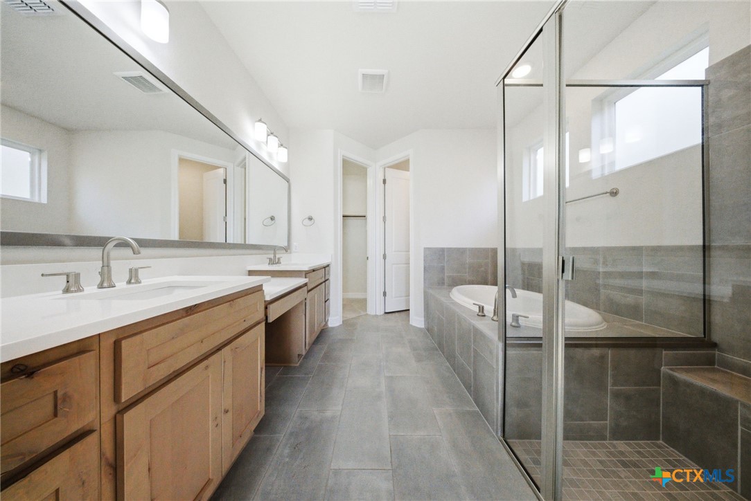 662 Hidden View Street New Braunfels, TX 78130 - Photo 23 of 46 a large bathroom with a double vanity sink a mirror and a shower