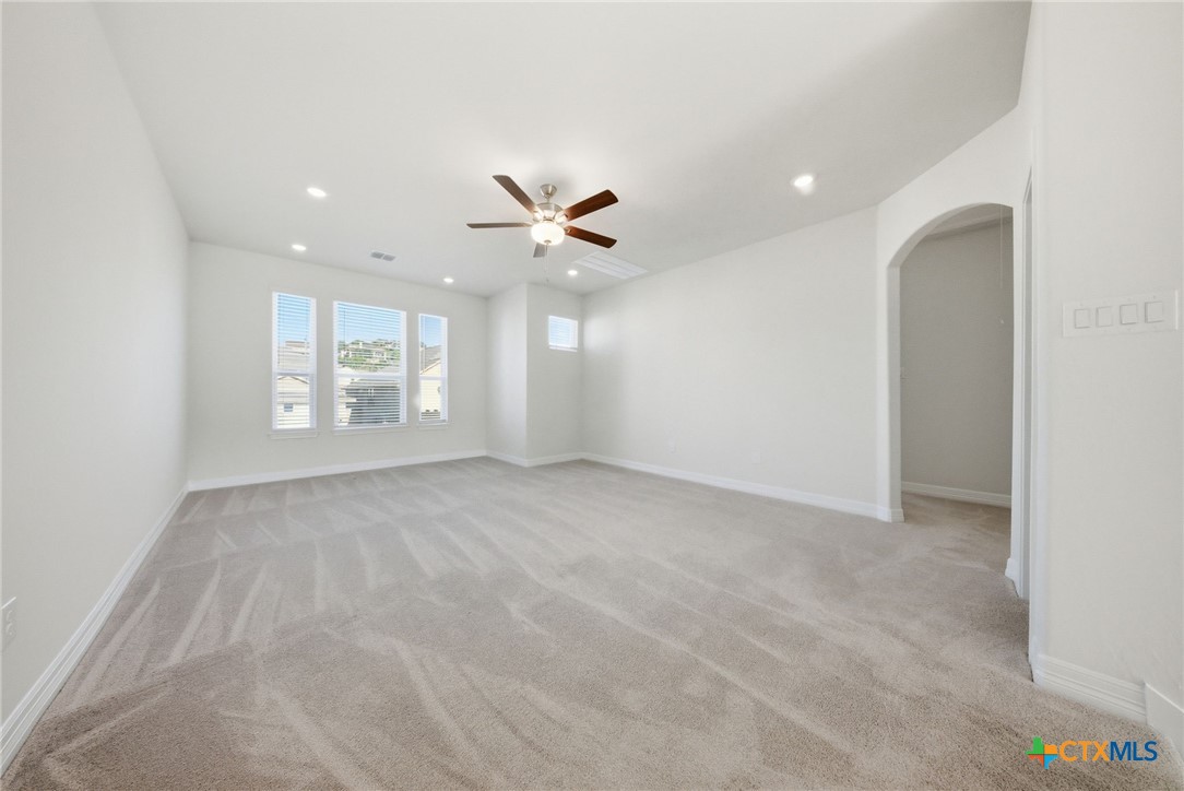 662 Hidden View Street New Braunfels, TX 78130 - Photo 31 of 46 an empty room with windows and ceiling fan