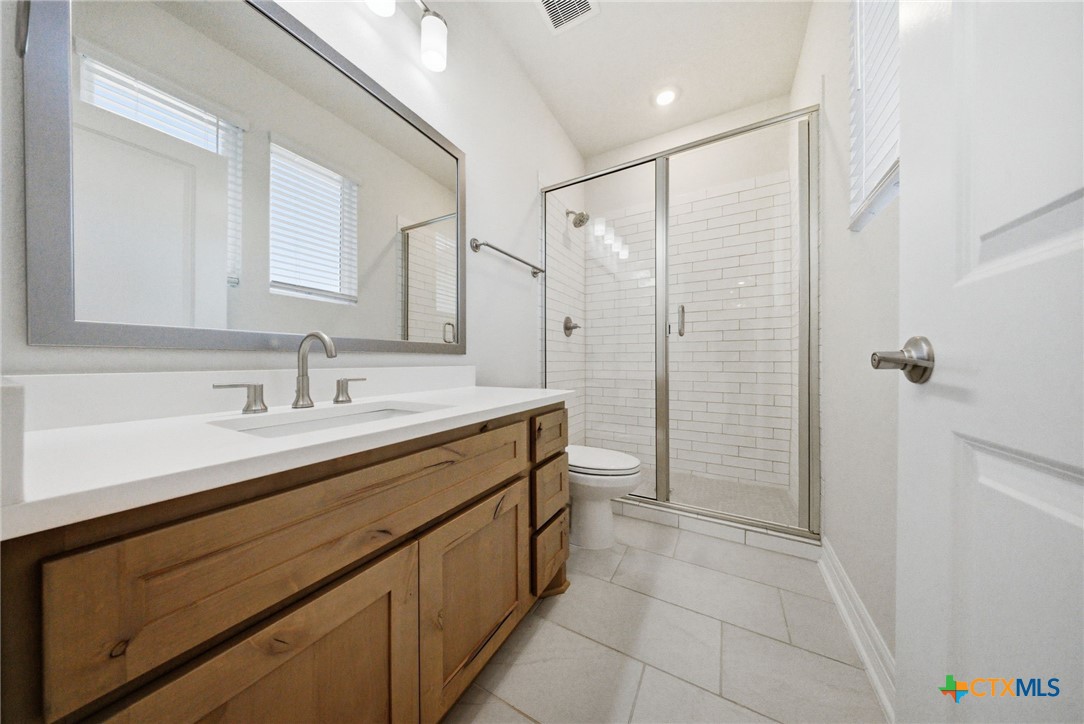 662 Hidden View Street New Braunfels, TX 78130 - Photo 32 of 46 a spacious bathroom with a shower sink and mirror