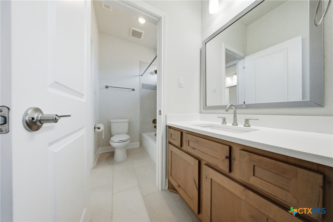 662 Hidden View Street New Braunfels, TX 78130 - Photo 37 of 46 a bathroom with a sink a toilet a shower and a mirror