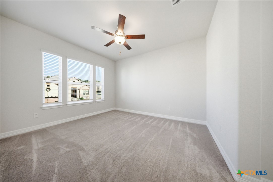 662 Hidden View Street New Braunfels, TX 78130 - Photo 39 of 46 an empty room with windows and fan